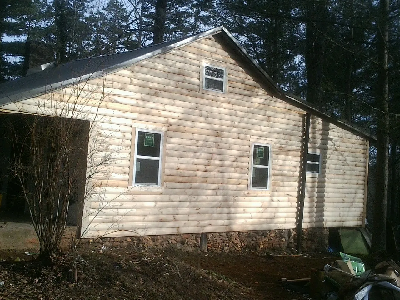 New log siding and dark metal roofing on a gable end in Cromwell